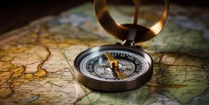 Compass in the foreground, with a map softly focused behind.